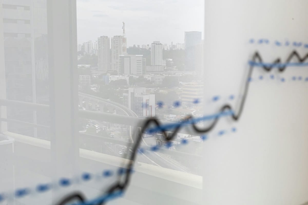 City skyline reflected across a data graph, restrained finance editorial image