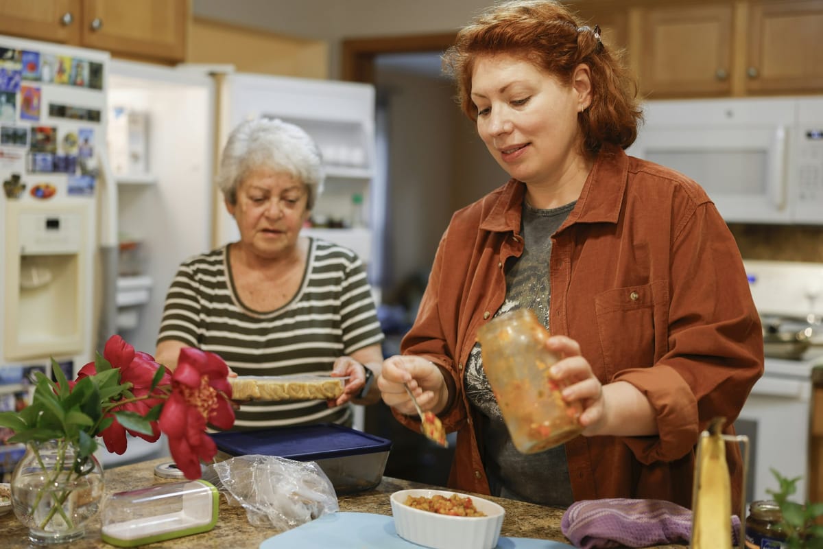 People preparing food together in a home kitchen, no recipe text or branding