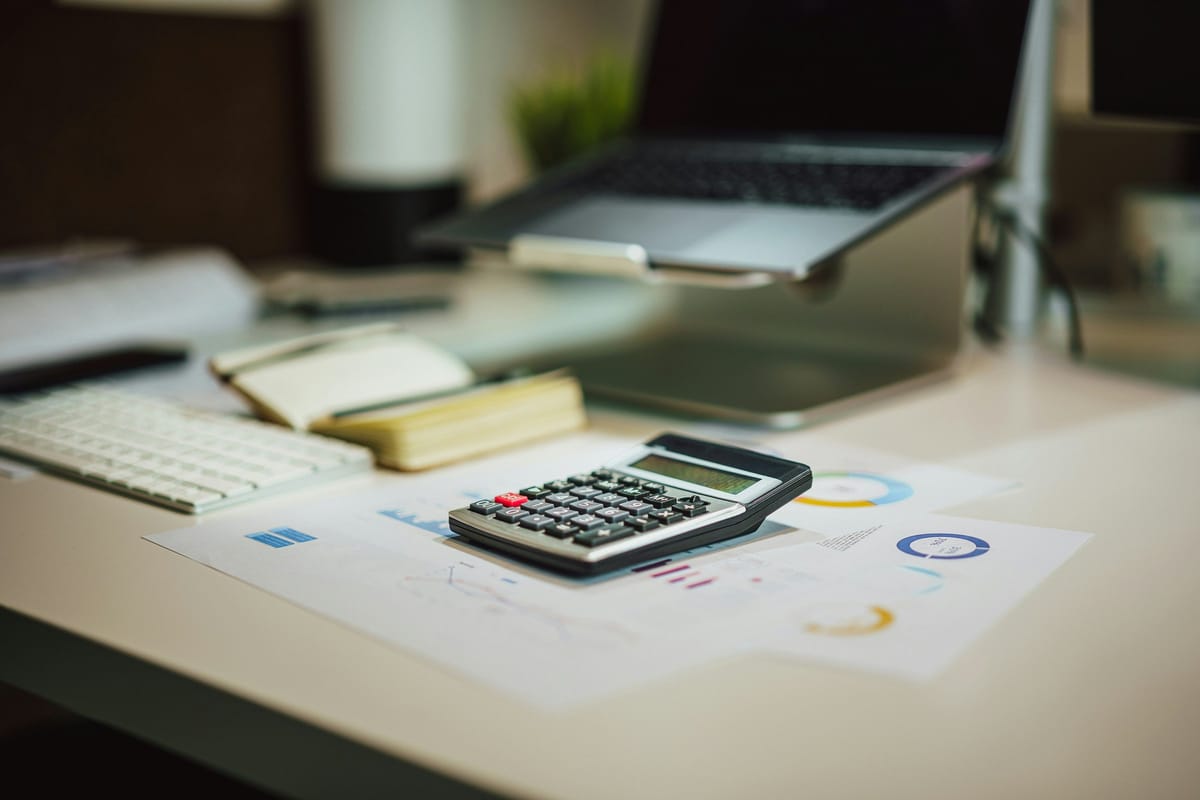Calculator and laptop on a home-office desk