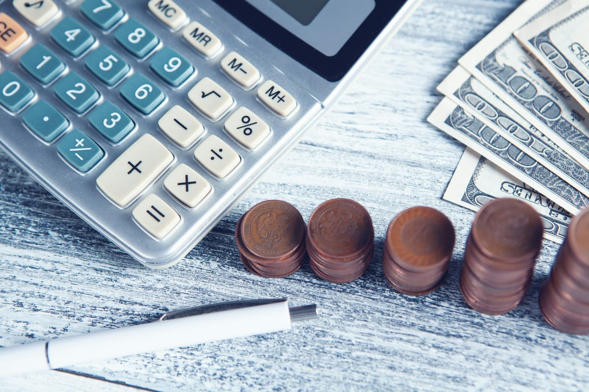 Calculator, pen, and money on a planning table