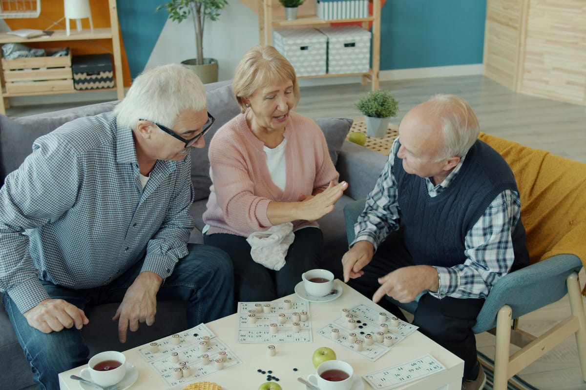 Older adults sharing coffee and a puzzle at home