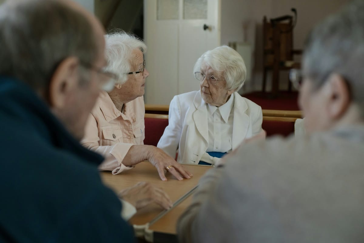 Seniors sitting around a table in conversation