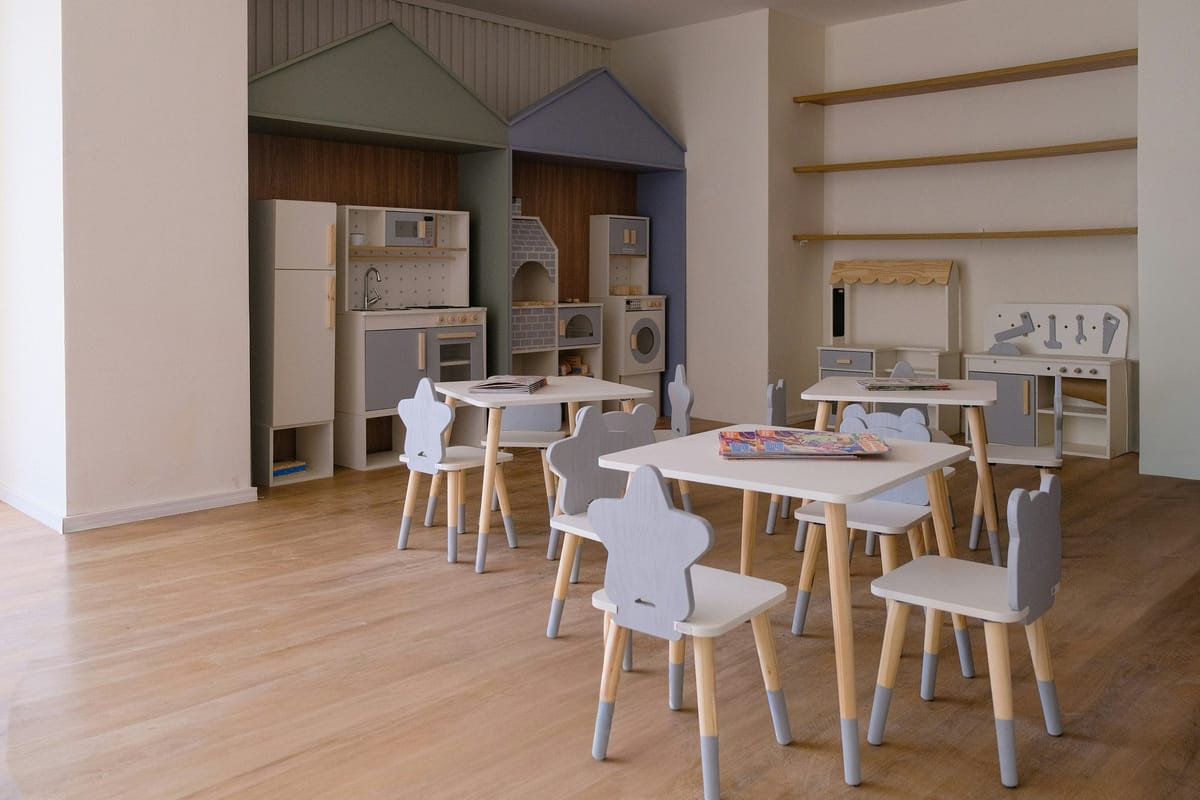 child-care verification context; empty classroom or daycare room; no visible faces; no readable text/logos; no personal data; clean editorial image