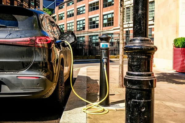 Electric car plugged into a public charging station on a city street