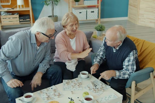 Older adults sharing coffee and a puzzle at home
