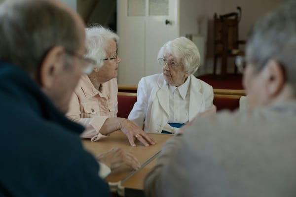 Seniors sitting around a table in conversation