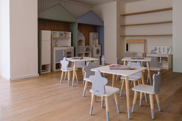 child-care verification context; empty classroom or daycare room; no visible faces; no readable text/logos; no personal data; clean editorial image
